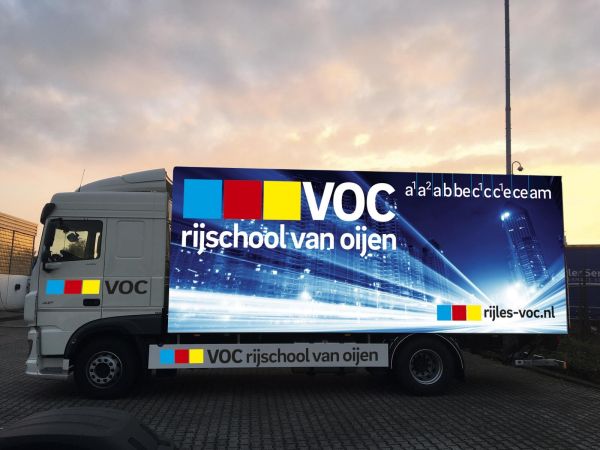 Een bedrukte vrachtwagen van Rijschool van Oijen waarin gelest kan worden om het vrachtwagenrijbewijs te halen.
